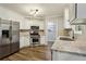 Kitchen with white cabinets, stainless steel appliances and stone countertops at 3641 Willow Club Dr, Loganville, GA 30052
