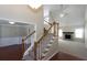 View of the stairs with wood banisters and carpeted steps looking into the living room and dining room at 3641 Willow Club Dr, Loganville, GA 30052