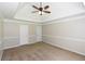 A large bedroom with neutral carpeting, tray ceiling, and decorative molding on the walls at 3641 Willow Club Dr, Loganville, GA 30052