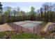 Outdoor tennis courts with a black fence surrounded by mature trees offering residents a place for recreation at 3641 Willow Club Dr, Loganville, GA 30052