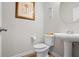 Half bath features a pedestal sink, round mirror, and tiled floors at 5152 Rapahoe Trl, Atlanta, GA 30349