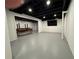 Finished basement area with a painted floor, exposed ceiling, and TV mounted on the wall at 1744 Millview Dr, Marietta, GA 30062