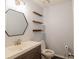 Contemporary bathroom features a vanity, modern sink, a hexagon mirror, and wall shelves at 1744 Millview Dr, Marietta, GA 30062