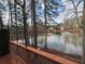 Relaxing view of the community lake with fountain, visible from a wooded backyard deck at 1744 Millview Dr, Marietta, GA 30062