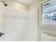 Bathroom with white tiled shower and open window for natural light at 2270 Old Concord Se Dr, Covington, GA 30016
