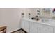 Bathroom featuring double sinks, white cabinets, a large mirror, and a wooden floor at 1241 Skylar Ridge Cir, Buford, GA 30519