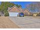 Exterior view of a charming one-story home with stone accents and attached garage on a concrete driveway at 1241 Skylar Ridge Cir, Buford, GA 30519