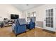 Relaxing living room area featuring hardwood floors, comfortable seating, a large window, and a view of the backyard at 1241 Skylar Ridge Cir, Buford, GA 30519