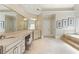 Bathroom featuring double vanities, makeup station, and a soaking tub at 9070 Waits Ferry Xing, Johns Creek, GA 30097