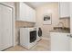 Convenient laundry room with a front load washer/dryer set and extra storage space at 9070 Waits Ferry Xing, Johns Creek, GA 30097