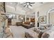 Open-concept living room with a stone fireplace and view of the staircase and kitchen at 9070 Waits Ferry Xing, Johns Creek, GA 30097