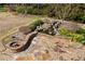 Stone patio featuring a built-in fire pit and relaxing waterfall perfect for outdoor entertaining at 9070 Waits Ferry Xing, Johns Creek, GA 30097