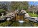 An eye-catching rock waterfall with lush plantings creates a backyard oasis at 9070 Waits Ferry Xing, Johns Creek, GA 30097