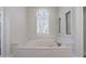 Bathroom featuring a built-in tub with jets and a window with shutters for natural light at 2650 Peachtree Battle Nw Pl, Atlanta, GA 30327