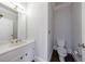 Cozy bathroom featuring a vanity with a sink, a toilet, and a mirror, complete with hardwood flooring at 2650 Peachtree Battle Nw Pl, Atlanta, GA 30327