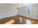 Empty dining room with hardwood floors, chandelier, and large windows offering ample natural light at 2650 Peachtree Battle Nw Pl, Atlanta, GA 30327