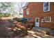 Rear exterior view of the brick home featuring an access door, windows, and space for utilities at 2650 Peachtree Battle Nw Pl, Atlanta, GA 30327