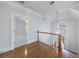 Upstairs hallway featuring hardwood floors, white trim, and lots of light from the window and open doorway at 2650 Peachtree Battle Nw Pl, Atlanta, GA 30327