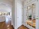 Hallway leading to the kitchen and a view of the bright sunroom with brick flooring through a glass-paned door at 2650 Peachtree Battle Nw Pl, Atlanta, GA 30327