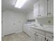 Clean laundry room features ample cabinet space, sink, washer, and dryer at 2650 Peachtree Battle Nw Pl, Atlanta, GA 30327