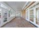 Bright sunroom with brick floor, many windows, ceiling fan, and multiple glass doors to let the light stream in at 2650 Peachtree Battle Nw Pl, Atlanta, GA 30327