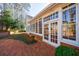 Sunroom featuring many windows and French doors leading to a brick patio and beautifully landscaped yard at 2650 Peachtree Battle Nw Pl, Atlanta, GA 30327