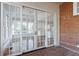 Glass sliding doors provide a glimpse into the bright, airy sunroom with white trim and brick flooring at 2650 Peachtree Battle Nw Pl, Atlanta, GA 30327