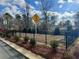 Community playground with safety fence and signage, surrounded by landscaping at 3015 Acacia Cir, Douglasville, GA 30135