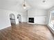 Open-concept living room featuring wood floors, a fireplace, and an open doorway at 6782 Gina Agha Cir, Lithonia, GA 30038