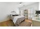 Cozy bedroom with a patterned bedspread, wood floors, and a decorative shelving unit at 912 Santa Anita Dr, Woodstock, GA 30189