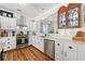 An updated kitchen is shown with white subway tile, white cabinetry, stainless steel appliances, and hardwood floors at 912 Santa Anita Dr, Woodstock, GA 30189