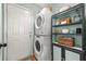 Functional laundry area with stacked washer/dryer and built-in shelving for storage at 912 Santa Anita Dr, Woodstock, GA 30189