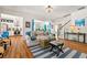 Open-concept living room flowing into the kitchen featuring a stylish rug, hardwood floors, and designer decor at 912 Santa Anita Dr, Woodstock, GA 30189