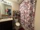 Bathroom with a sink, toilet, and shower/tub combo with patterned shower curtain at 1720 Danville Dr, Mcdonough, GA 30253