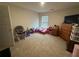 Spacious bedroom with carpet flooring, a window, and a TV on top of a wooden dresser at 1720 Danville Dr, Mcdonough, GA 30253