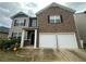 Two-story home with brick and siding, two-car garage, and covered front entry at 1720 Danville Dr, Mcdonough, GA 30253