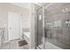 Bright bathroom features a glass shower with gray tile, soaking tub, and wood-like tile floors at 2066 Charcoal Ives Rd, Lawrenceville, GA 30045