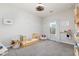 Light-filled bedroom with gray carpet, ceiling fan, and neutral walls and décor at 2066 Charcoal Ives Rd, Lawrenceville, GA 30045