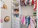 Organized walk-in closet with hanging clothes, toys and shoe storage shelves at 2066 Charcoal Ives Rd, Lawrenceville, GA 30045