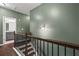 Hallway with hardwood floors leading to bedrooms and bathrooms, accented by a light green wall at 2066 Charcoal Ives Rd, Lawrenceville, GA 30045