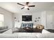 Open living room showcasing a media console, a ceiling fan, and neutral walls with framed pictures at 2066 Charcoal Ives Rd, Lawrenceville, GA 30045