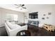 Bright living room featuring hardwood floors, a ceiling fan, and comfortable white and gray couches at 2066 Charcoal Ives Rd, Lawrenceville, GA 30045