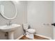 Powder room featuring a pedestal sink, white toilet, framed oval mirror, and wood-look vinyl flooring at 3330 Valley Vista Se Rd, Smyrna, GA 30080