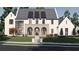 Stately two-story home with an arched entryway, complemented by a manicured lawn and mature trees at 1580 Mayfield Rd, Alpharetta, GA 30009