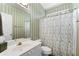 Traditional bathroom with green striped wallpaper, white vanity, toilet and shower at 2091 Suwanee Woods Ln, Duluth, GA 30097