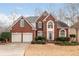 Charming two-story brick home with a manicured lawn and two-car garage offers great curb appeal at 2091 Suwanee Woods Ln, Duluth, GA 30097