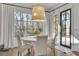 Cozy dining area featuring natural light from large windows, white chairs, and a stylish light fixture at 3224 Lanier Ne Dr, Atlanta, GA 30319