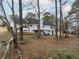 View of backyard with mature trees and a charming home featuring a deck and outdoor space at 1010 James Madison Ct, Mcdonough, GA 30253