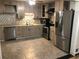 Well-lit kitchen features stainless steel appliances and light-colored cabinets and backsplash at 1625 Linda Dr, Decatur, GA 30032