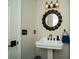 Stylish powder room with modern vanity, decorative mirror, and chic lighting fixtures at 8960 Terrace Club Dr, Roswell, GA 30076